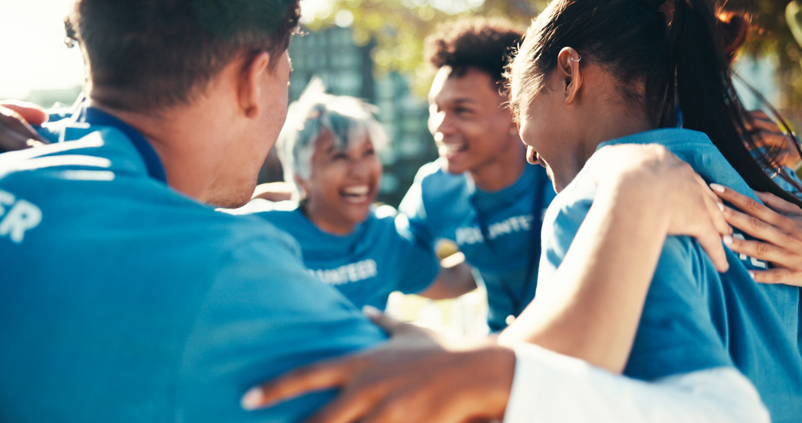 Volunteer, people or group in circle outdoor for synergy, collaboration or donation. Charity, team or huddle together for support, excited or hands for community service in cooperation for motivation